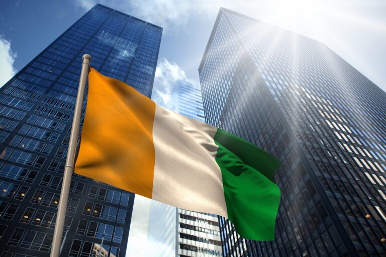 Ivory,Coast,National,Flag,Against,Low,Angle,View,Of,Skyscrapers